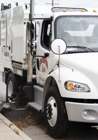 Street cleaning vehicle cleaning curb